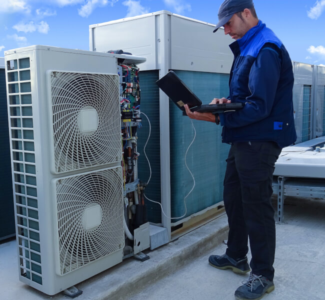 Wąż skroplin biegnący od klimatyzatora na zewnątrz budynku