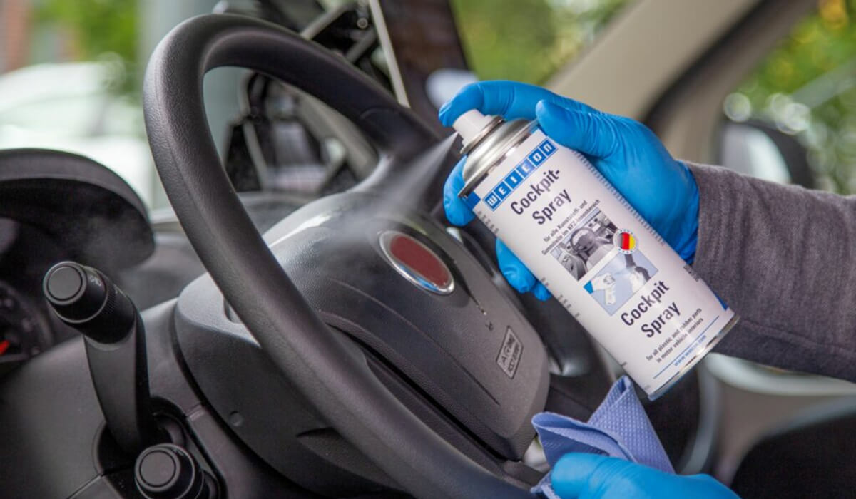 Czyszczenie deski rozdzielczej sprayem do kokpitu Aplikacja WEICON Cockpit Spray na plastikowe elementy wnętrza w celu ochrony przed kurzem