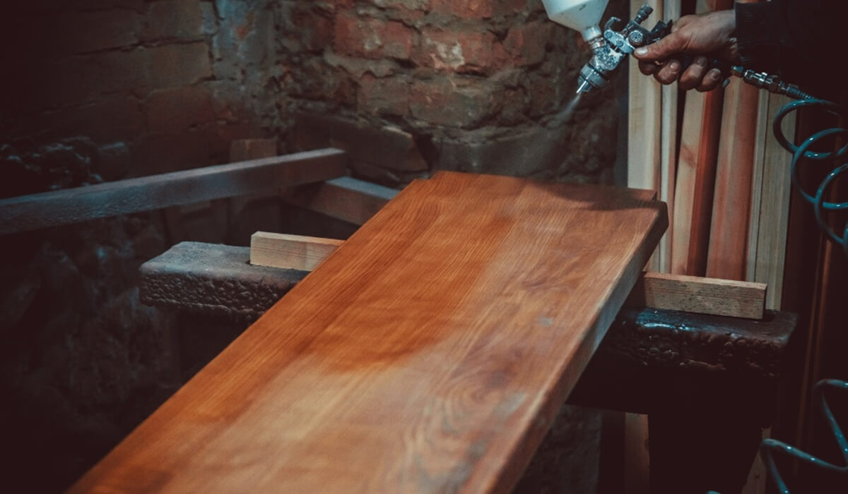 Początkujący lakiernik trzymający pistolet lakierniczy w dłoni, gotowy do pracy