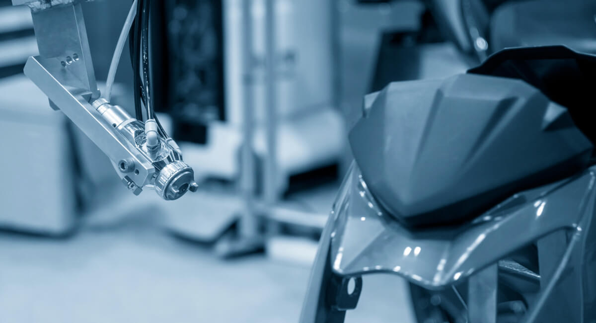 Pneumatyczny pistolet lakierniczy używany do precyzyjnego nakładania lakieru na owiewki sportowego motocykla Sprzęt do lakierni - pistolet lakierniczy