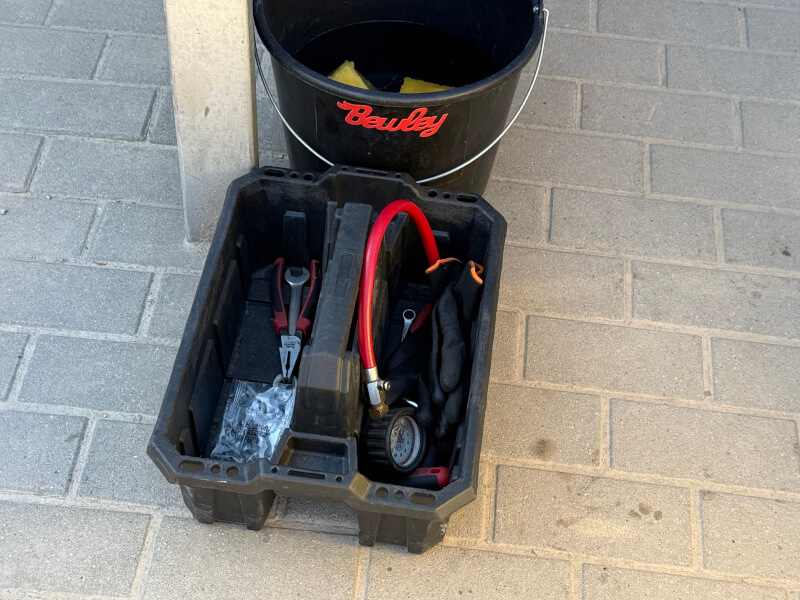 Mechanik używający pistoletu do pompowania kół