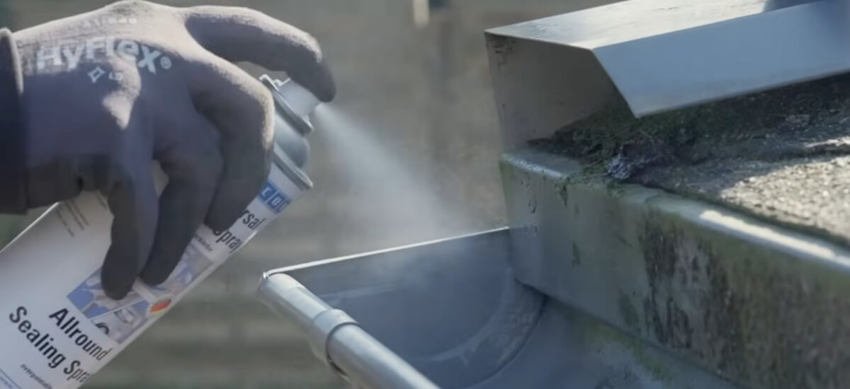Punktowe nakładanie uniwersalnego sprayu WEICON Allround Sealing Spray na nieszczelne miejsca w rynnie