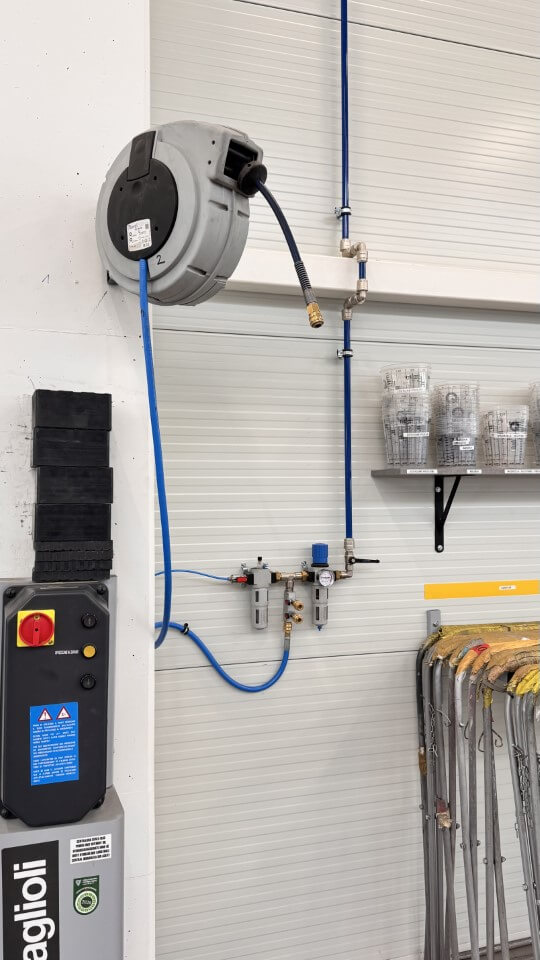 Wnętrze sprężarkowni z widocznymi sprężarkami i innymi urządzeniami