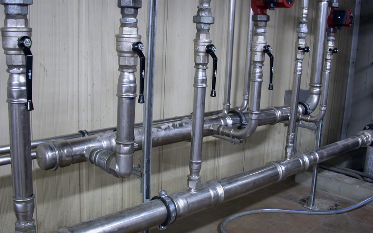 Różnorodne złączki Effebi-Press, w tym kolana, trójniki i mufy, ilustrujące ich uniwersalne zastosowanie w instalacjach Różnorodność złączek Effebi-Press - Kolana, trójniki, mufy - Uniwersalne zastosowania