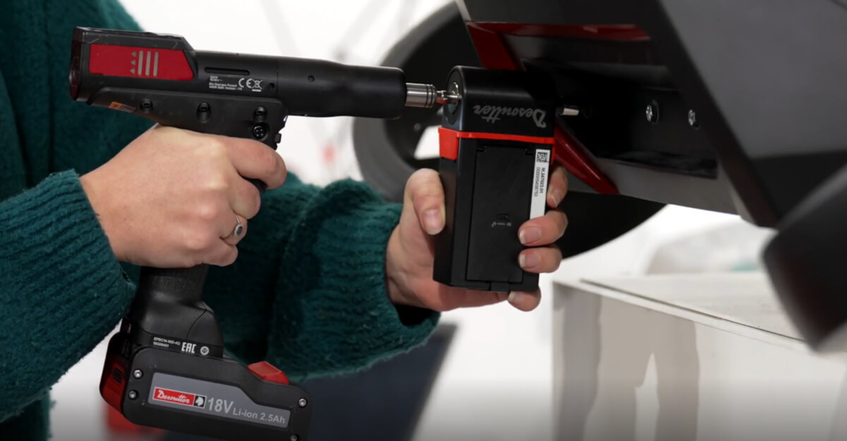 Kontrolowany montaż modułów baterii EV z Desoutter Operator montujący pakiet akumulatorów do pojazdu elektrycznego za pomocą narzędzia Desoutter